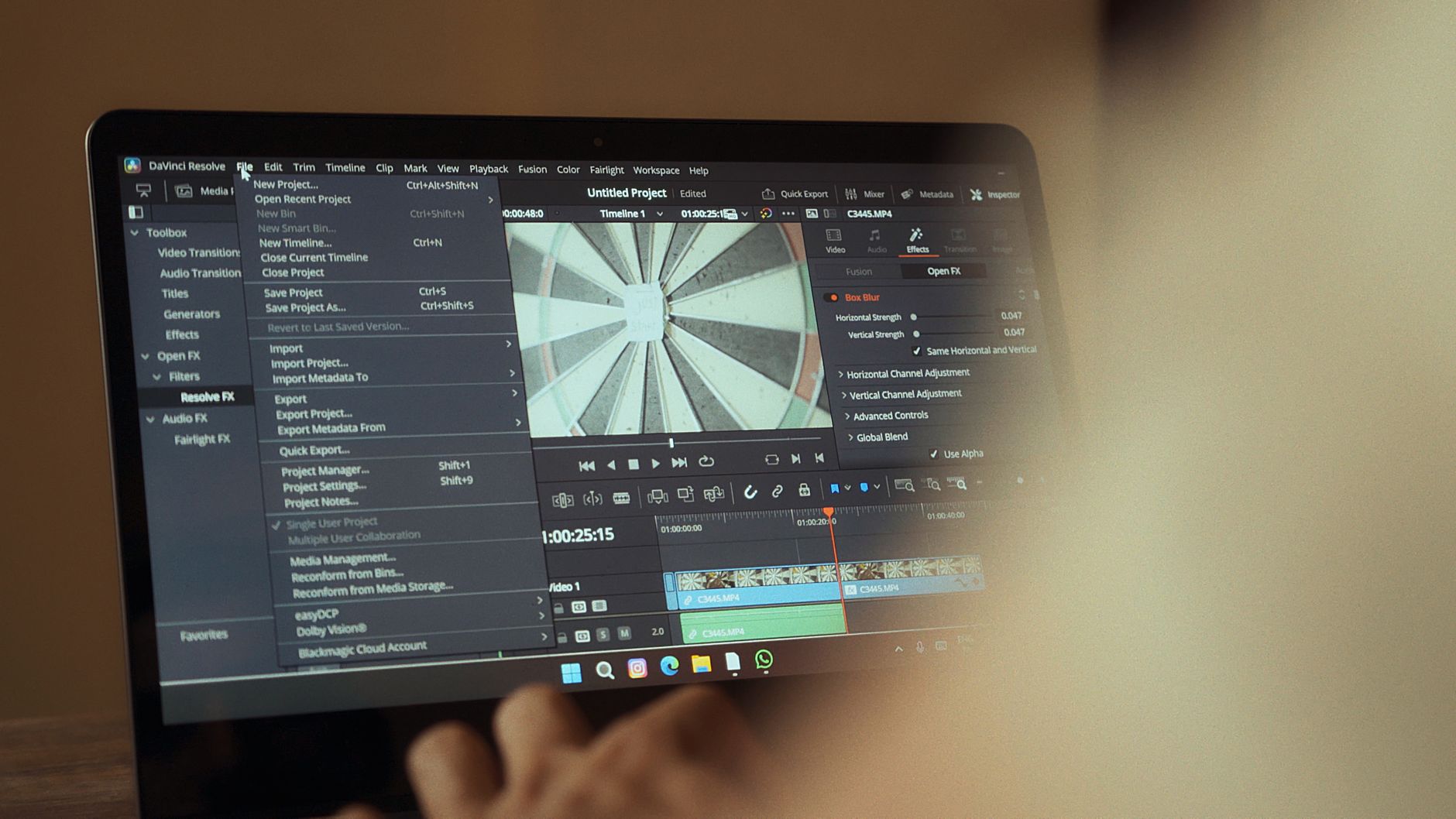 Close view of a laptop screen showing video editing software with a timeline and effects panel